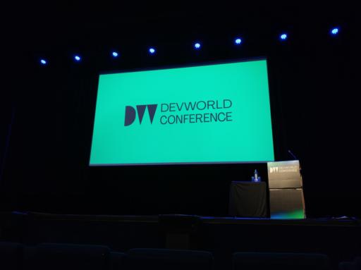 Palco com uma tela branca com logo e o nome da conferência: Devworld Conference